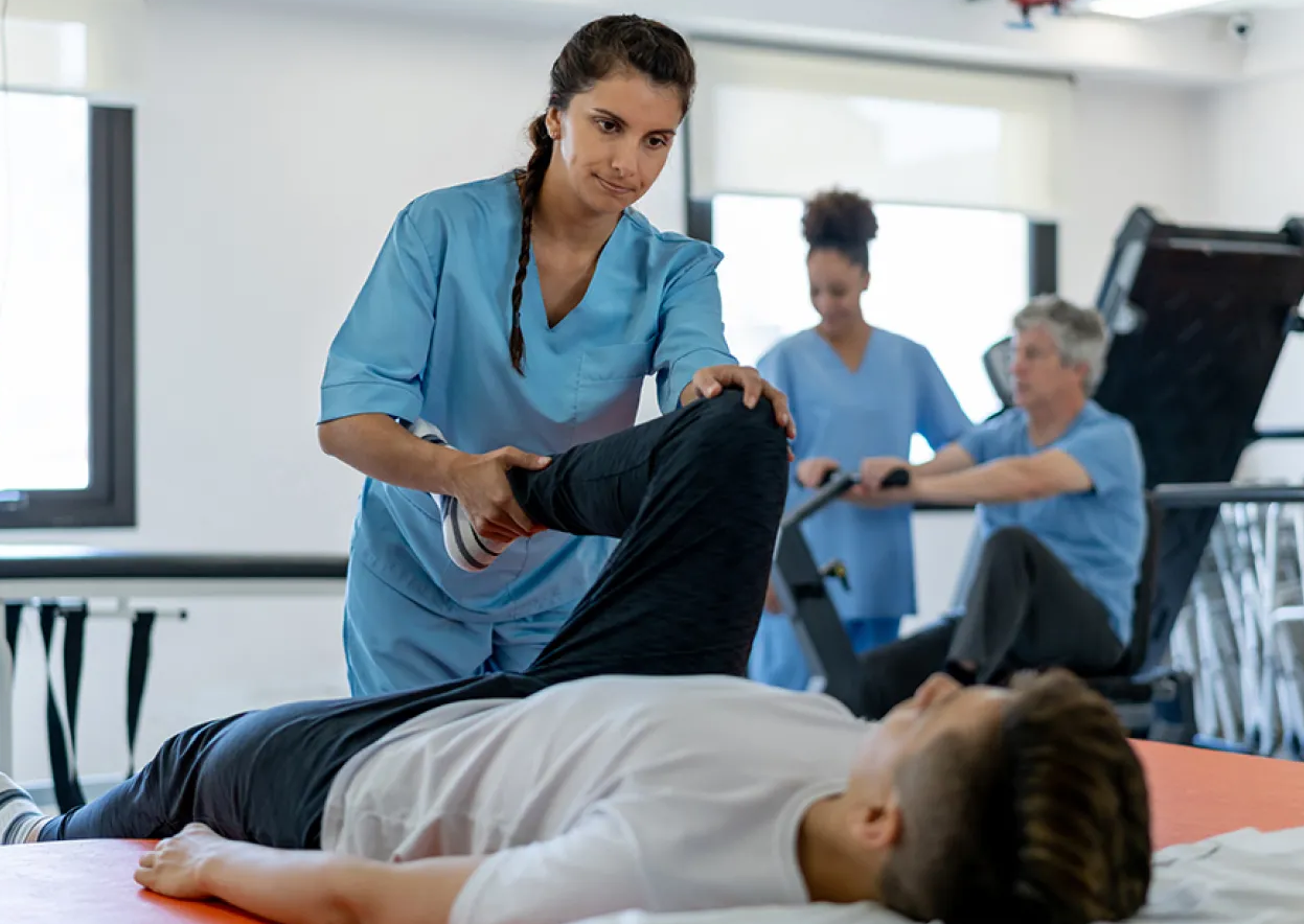 Physiotherapist helping diverse patients recover from injuries and improve mobility through personalized physiotherapy treatments